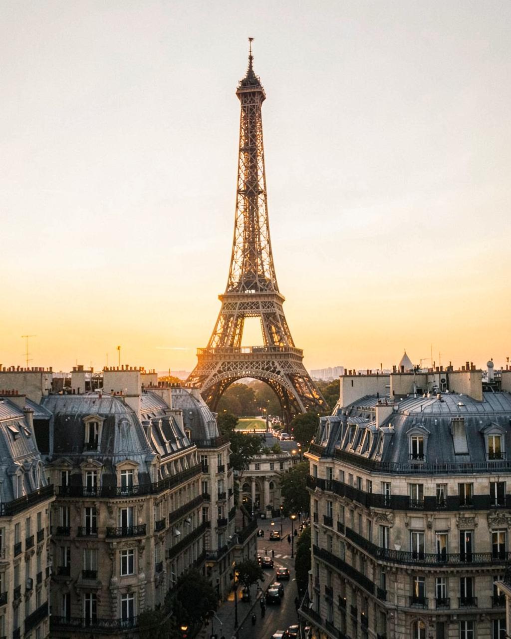 Eiffel Tower above Parisian rooftops at golden hour